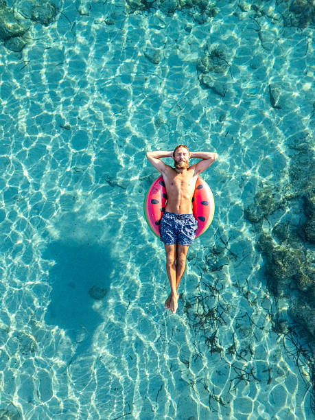 istock Man Relaxing on Inflatable Ring in Clear Water 2226629877