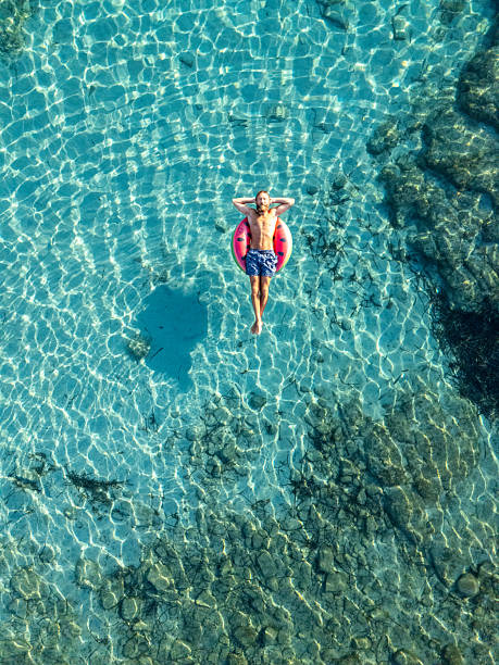 istock Man Relaxing on Inflatable Ring in Clear Water 2226629904