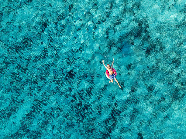 istock Man Relaxing on Inflatable Ring in Clear Water 2226629942