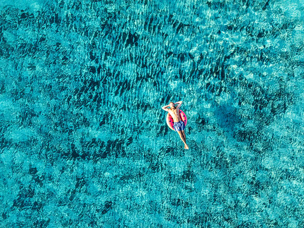 istock Man Relaxing on Inflatable Ring in Clear Water 2226629946