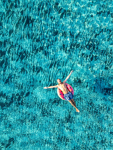 istock Man Relaxing on Float in Clear Blue Water 2226629987