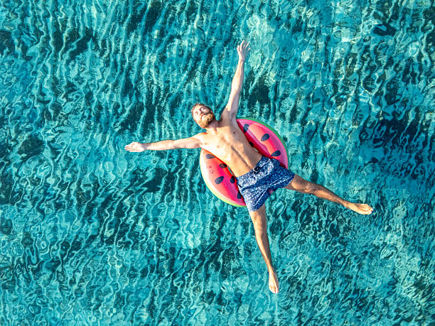 istock Man Relaxing on Watermelon Float in Clear Pool 2226630051