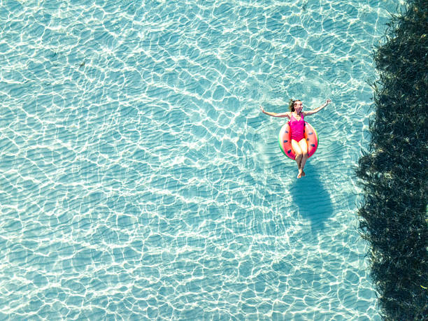istock Woman Relaxing on Inflatable Ring in Clear Water 2226630392