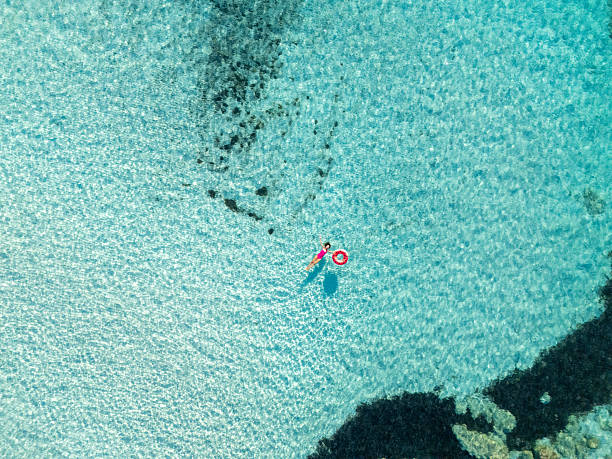 istock Woman Floating in Clear Blue Ocean Water 2226630647