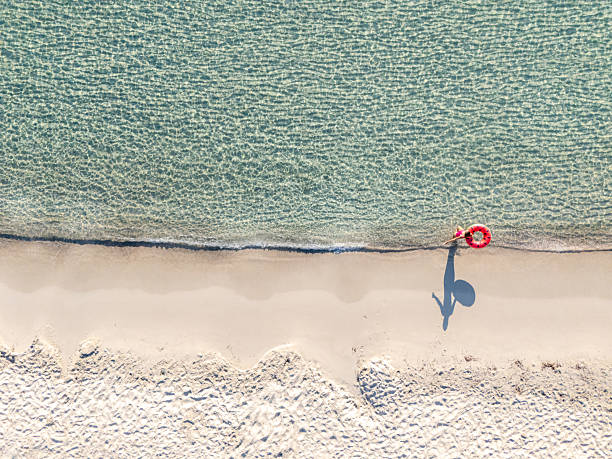 istock Woman Walking on Beach Holding Red Float 2226630707