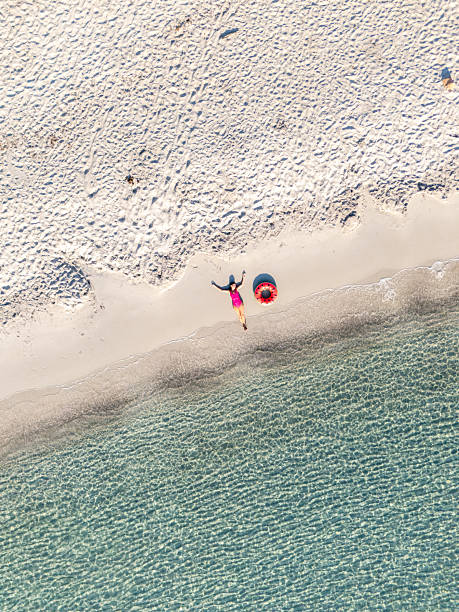 istock Woman Relaxing on Sandy Beach Near Clear Water 2226630786