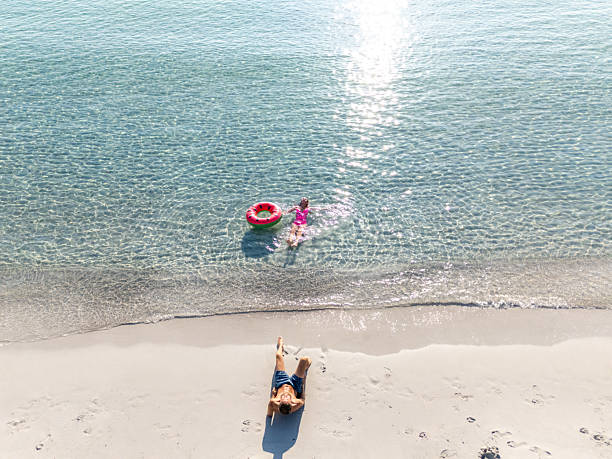 istock Woman Floating in Water with Man on Beach 2226630847