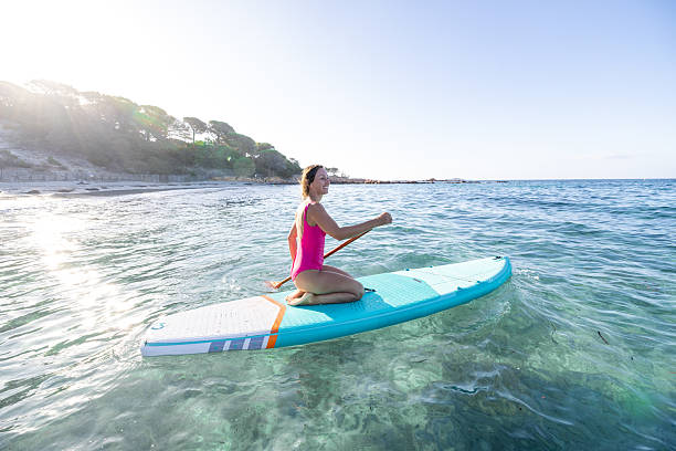istock Woman Kneeling on Paddleboard in Crystal-Clear Water 2226631887