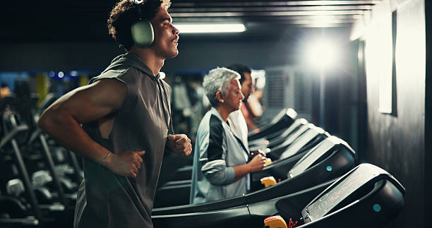 istock Workout, man and running on treadmill with headphones at night for speed training, endurance challenge and playlist. Fitness, evening exercise and music for calorie burning and cardio routine at gym 2226632187
