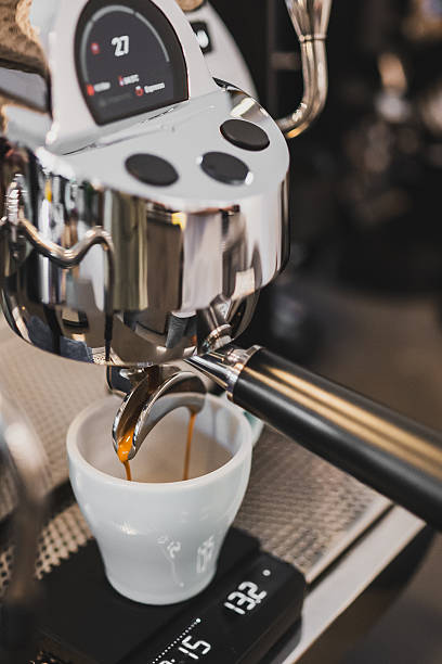 istock Close-up of espresso machine brewing coffee into a white cup on a digital scale, highlighting precision and modern café equipment. 2226633984