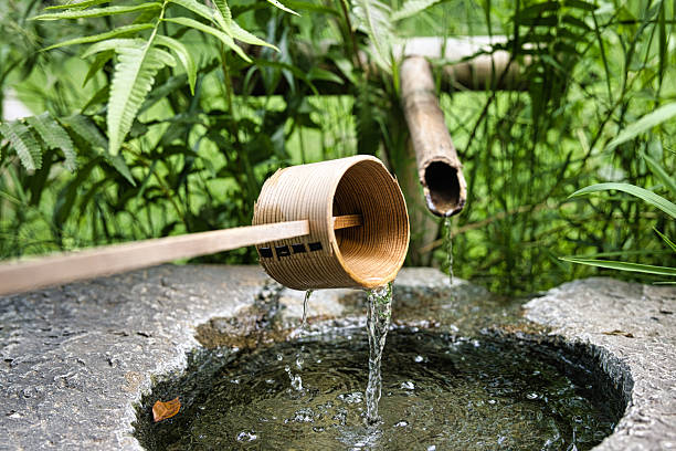 istock A Bamboo Dipper Fetching Clear Water from a Stone Basin in a Serene Garden 2226634419
