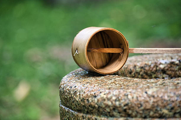 A Wooden Dipper Resting on a Stone Stool in a Serene Outdoor Setting
