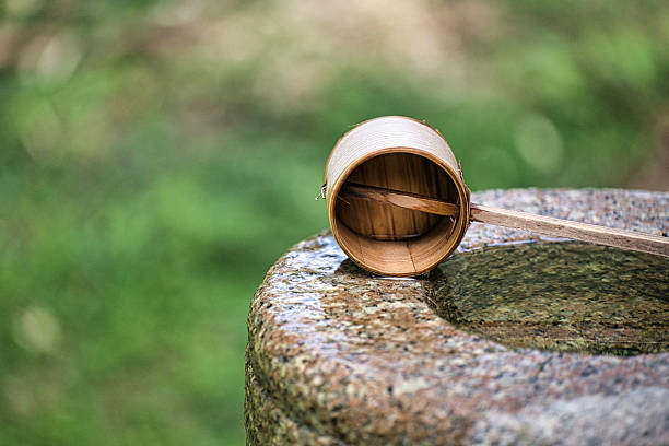 A Wooden Dipper Resting on a Stone Platform in a Serene Outdoor Setting