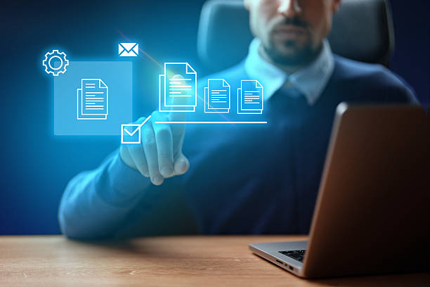 istock Professional man interacting with digital documents on a laptop at a desk during evening hours 2226636548