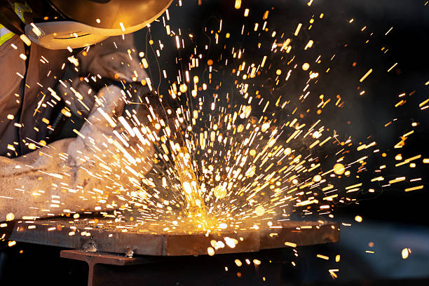 istock Wearing fireproof protective workwear and helmet, an experienced engineer welds metal in a manufacturing plant. The image captures heat, sparks, and craftsmanship in the construction and steel industry. 2226637102