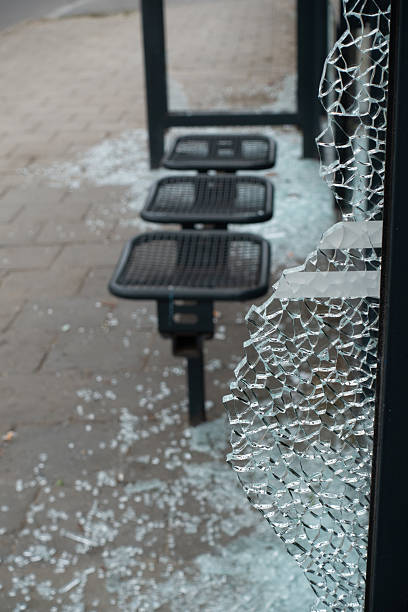 istock Broken glass at bus stop with shattered pieces scattered on the pavement and empty seating area 2226639262