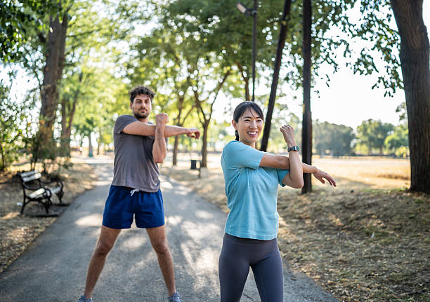 istock Young woman stretching arms before exercising in the park 2226639324