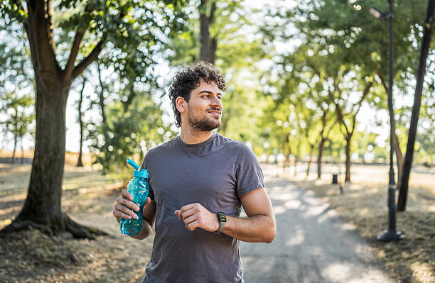 istock Young man running in the park with water bottle 2226641641