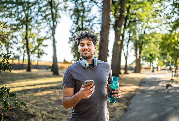 istock Young sporty man using smartphone in the park 2226643144
