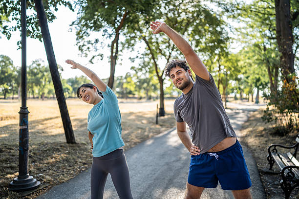 istock Young couple stretching in the park before exercising 2226643303