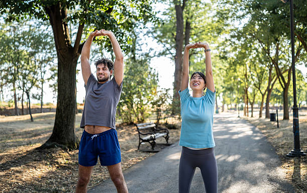 istock Young couple stretching together in the park before exercising 2226643464
