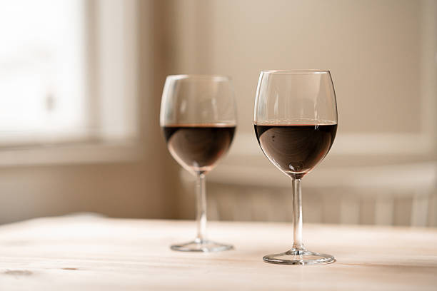 istock Two glasses of red wine on a softly lit wooden table 2226645247