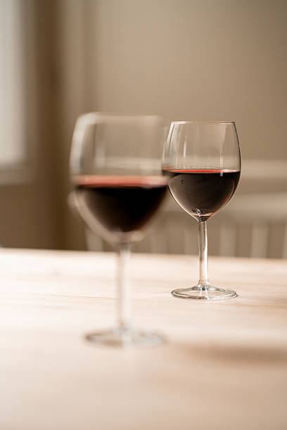 istock Two glasses of red wine on a wooden table in soft light. 2226645253