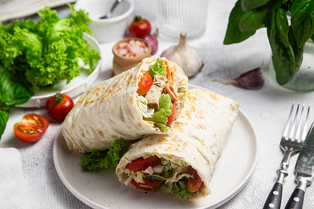 istock Appetizing Shawarma with chicken and fresh vegetables on a light background 2226647273