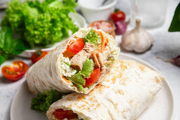 istock Appetizing Shawarma with chicken and fresh vegetables on a light background 2226647275