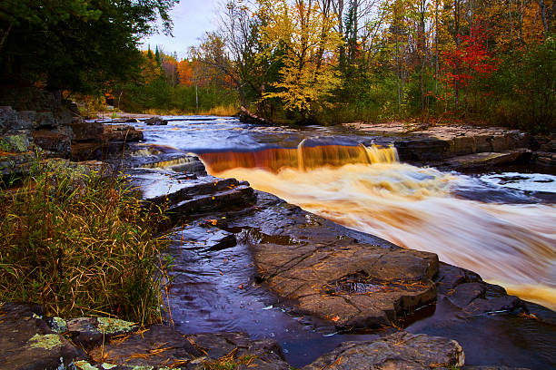 Bracebridge Falls runs into Muskoka River with Trans Canada Trail and autumn foliage colors in Ontario, Canada