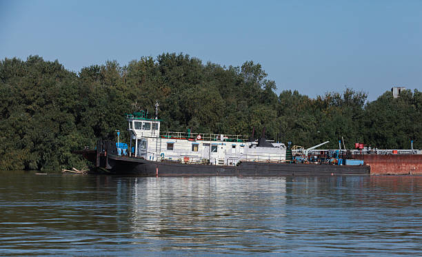 istock Tugboat stationed by a serene riverbank on a sunny day 2226651402