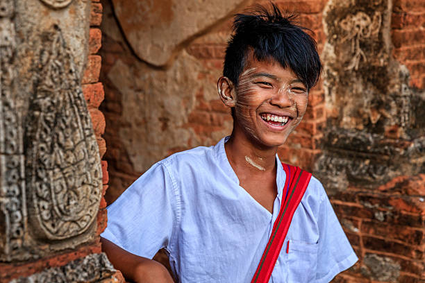Young Burmese schoolboy with thanaka standing in the ancient temple of Bagan, Myanmar (Burma)