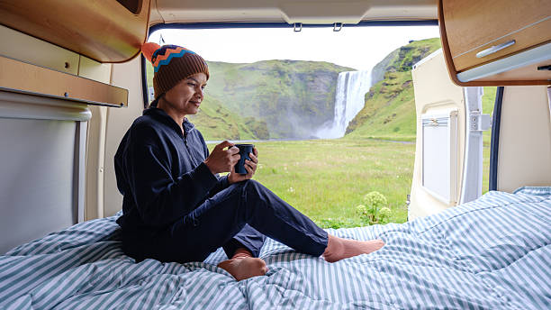 istock Relaxing with a warm drink in a camper van by a stunning Icelandic Skogafoss waterfall 2226657313