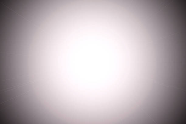 bright white light at the center, radiating outward into a soft gradient that transitions to dark gray at the edges. The effect resembles a lens flare or a glowing orb, creating a radial burst of light.