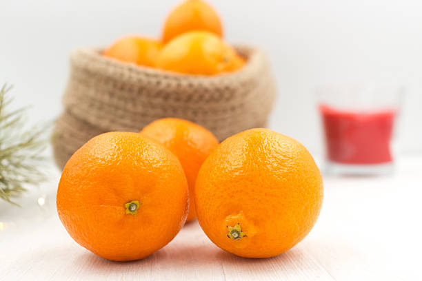 Fragrant tangerines in a knitted jute basket. Fragrant, tasty, winter fruit creates a festive, cozy mood.