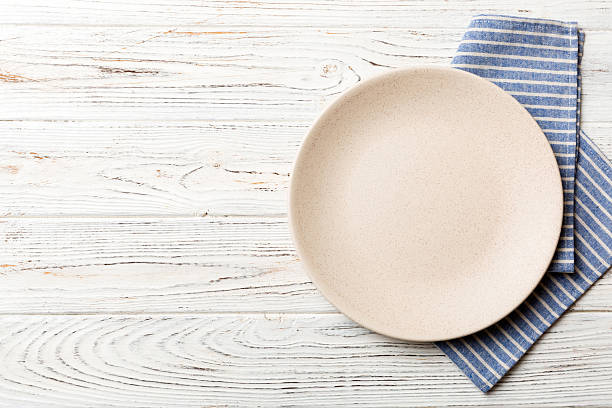 istock Top view on colored background empty round white plate on tablecloth for food. Empty dish on napkin with space for your design 2226666208