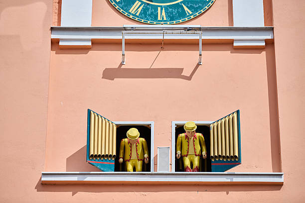 Gvardeysk, Russia - 13.05.2025 - Iconic town hall clock featuring ornate roman numerals and mechanical dolls. Bright peach exterior enhances historic charm and adds to touristic appeal