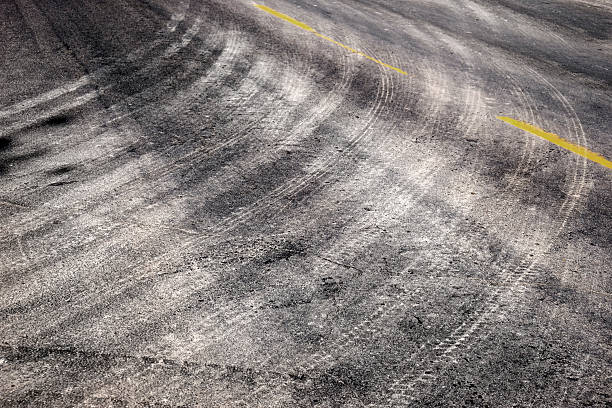 istock Tire Tracks Turning on Road with Yellow Stripe Lines 2226671547