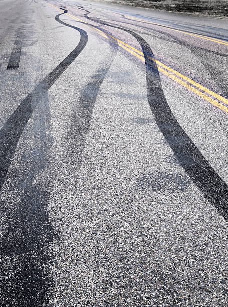 istock Tire Tracks on Road Burning Rubber Peeling Out Skid Marks on Asphalt 2226671569