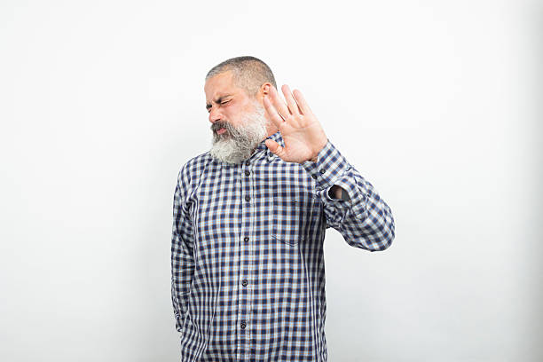 Mature man with beard showing stop sign with hand and disgusted face expression