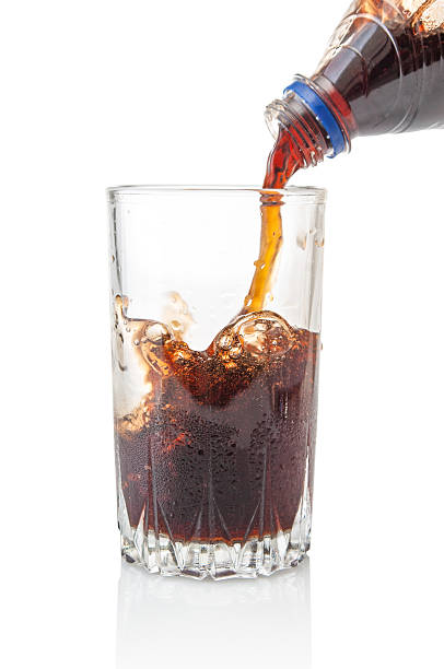 istock Pouring cola from bottle into glass isolated on white background 2226677914