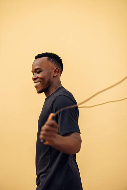 istock Smiling man skipping rope against a neutral orange background 2226681954