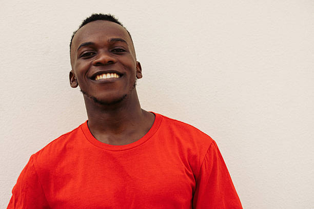 istock Smiling Young Man in Red Shirt Against Bright Neutral Background 2226682308