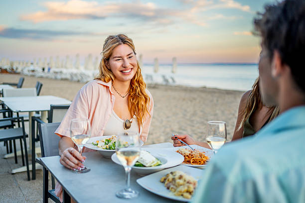 istock Friends enjoying dinner at beach restaurant during sunset 2226683381