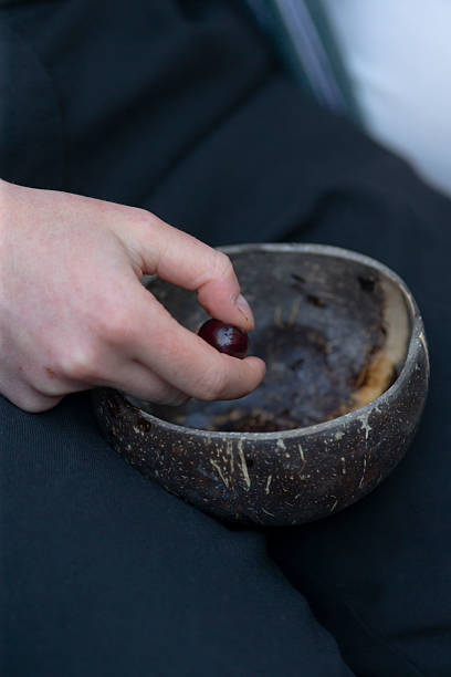 A person is delicately holding a juicy cherry in a bowl