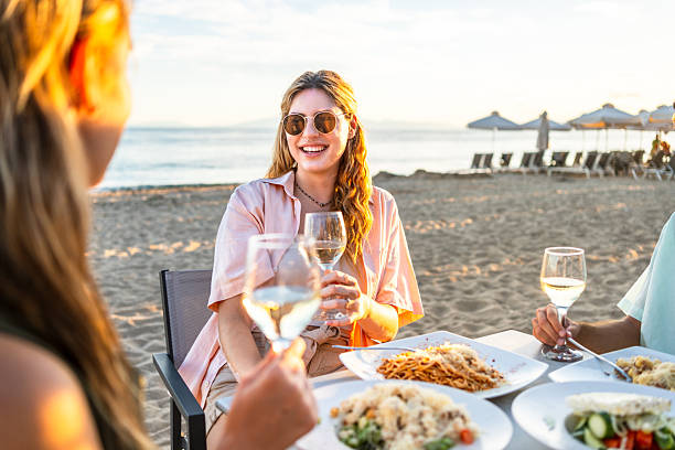 istock Friends enjoying a beachfront dinner at sunset 2226685245