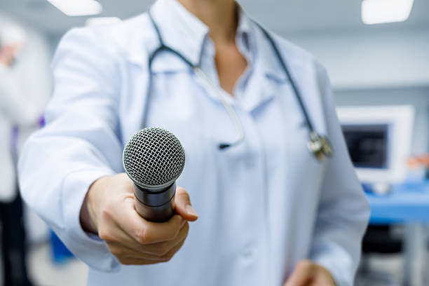 Doctor holds microphone for an interview in clinic.