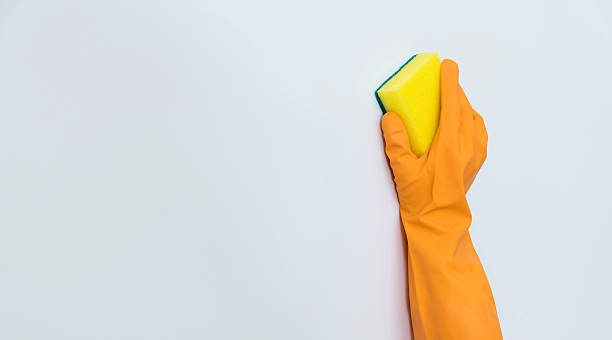 istock Woman hand cleaning white wall with sponge 2226692225