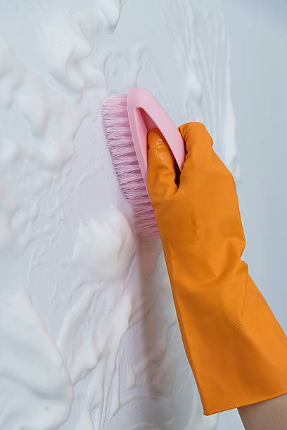 istock Woman hand cleaning blue wall with brush 2226692232