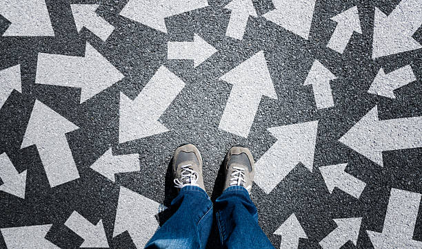 istock Taking decisions for the future, man standing with multitude of arrows in different direction 2226692671